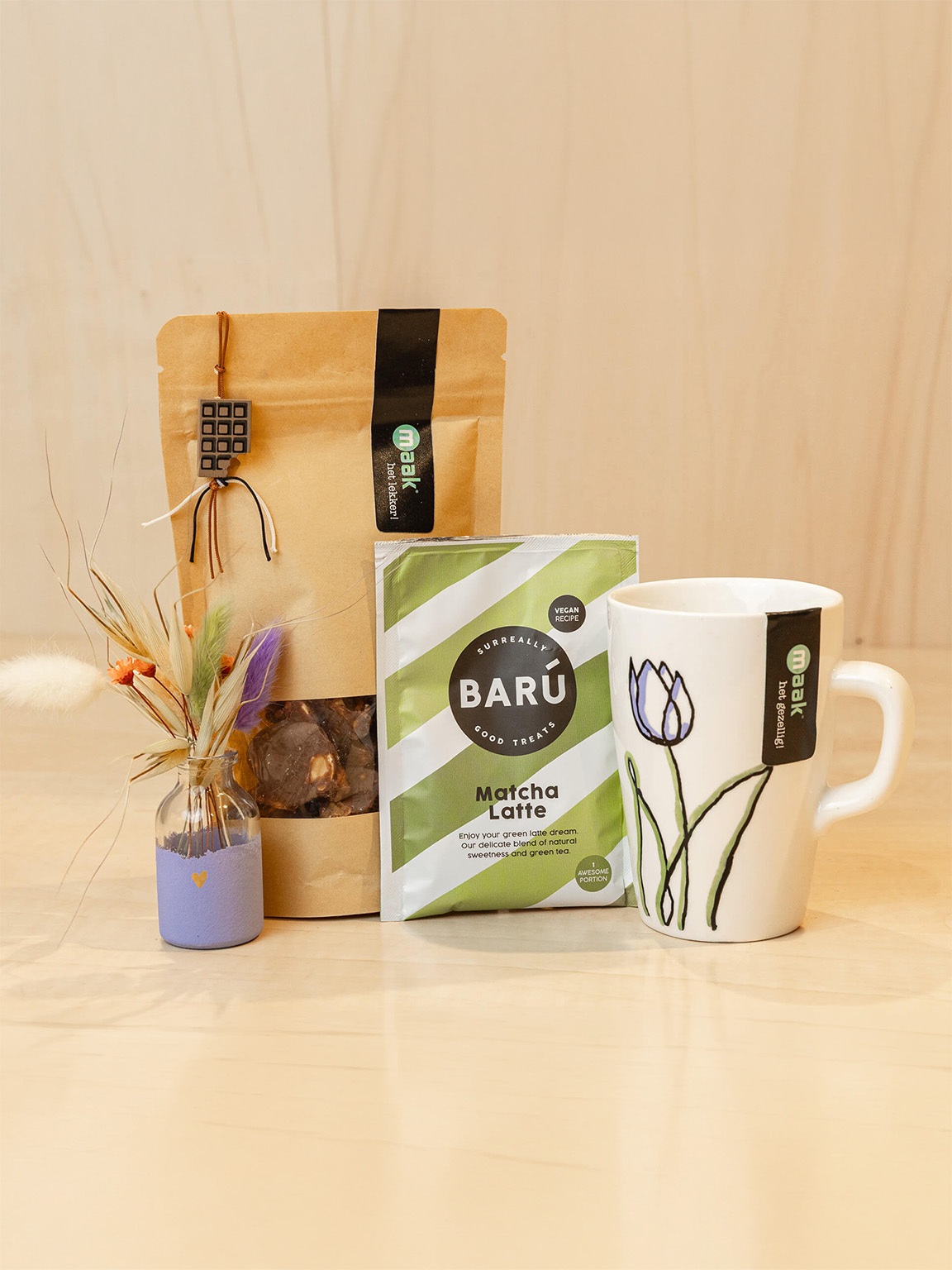 Cadeaupakket met betekenis van Makers & Merken Een samengesteld cadeaupakket van Makers & Merken met een beschilderde mok, lekkernijen, drankje en decoratie. Een origineel cadeau met producten van de makers.